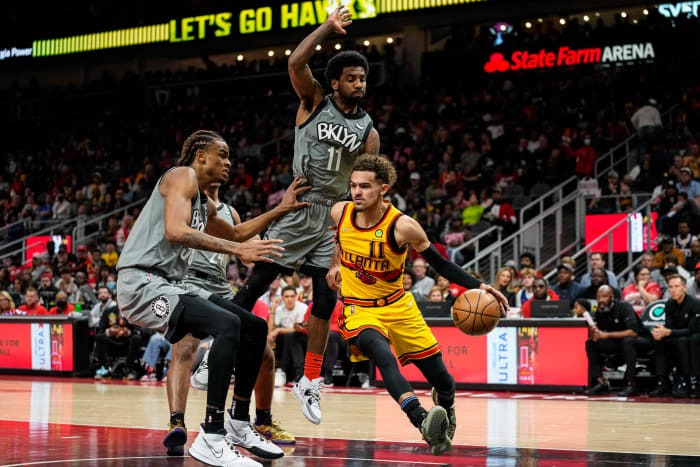 Apr 2, 2022; Atlanta, Georgia, USA; Atlanta Hawks guard Trae Young (11) dribbles past Brooklyn Nets guard Kyrie Irving (11) and forward Nic Claxton (33) during the second half at State Farm Arena.